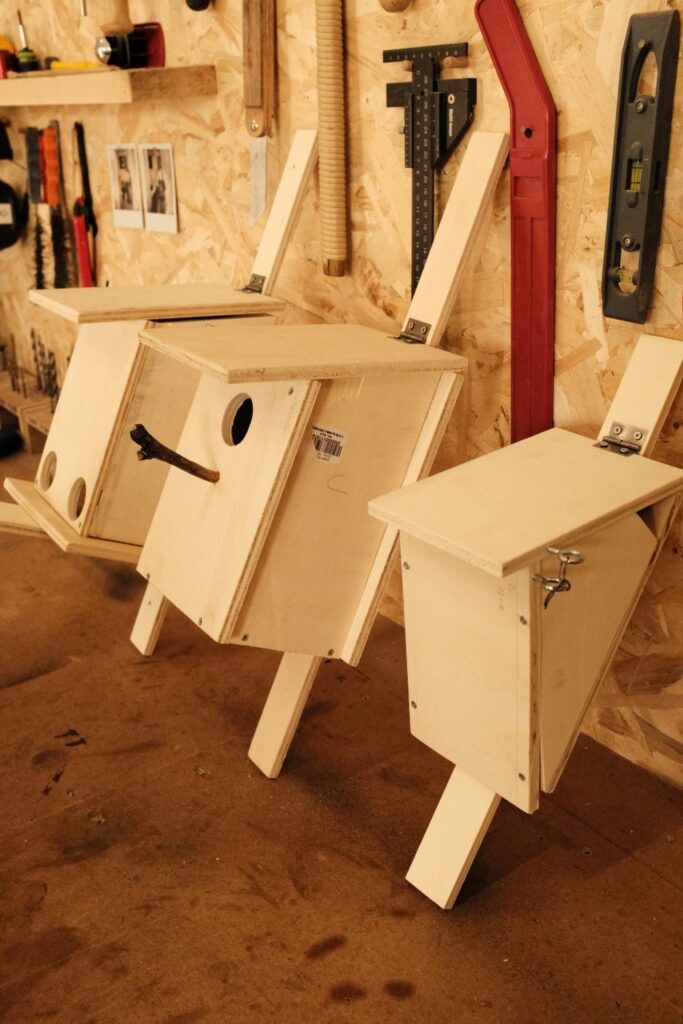 Casette in legno autoprodotte appoggiate alla parete del laboratorio